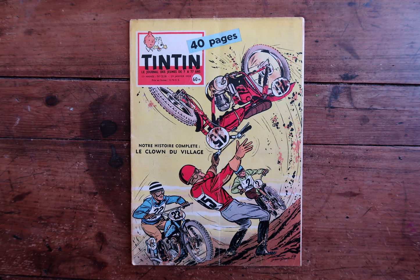 Close-up of the cover art on a 1959 French Tintin comic book magazine showing an action-packed racing scene with motorcycles and riders, with the iconic Tintin header and issue details.

