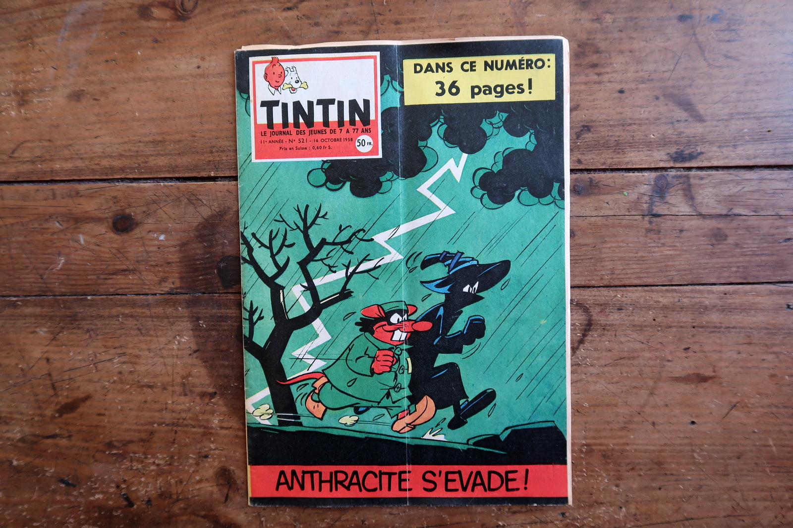 Vintage October 16, 1958 Tintin magazine issue N°521 displayed flat, measuring approximately 8.3 x 11.8 inches, with French language text and bande dessinée artwork, showing a central vertical cover fold.

