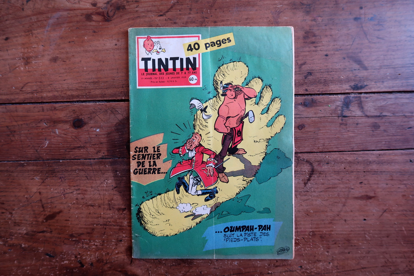 Vintage January 8, 1959 Tintin magazine issue N°531 displayed flat, measuring approximately 8.3 × 11.8 inches, with French language text and bande dessinée artwork, showing heavy cover wear including creasing, warping, scuffing, and label residue.

