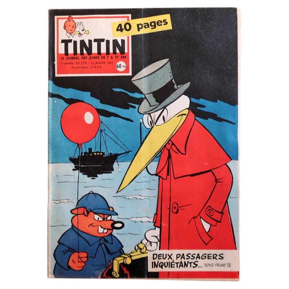 Front cover of Journal Tintin N°535 from February 5, 1959, featuring a visually arresting mid-century thriller illustration: a towering anthropomorphic bird villain in a sweeping crimson red coat and grey top hat looms over a squat red-faced accomplice clutching a golden detonator box, with a red balloon floating ominously between them and a steamship silhouetted on a moonlit sea behind, with the teaser "Deux Passagers Inquiétants… Voir Page 19."

