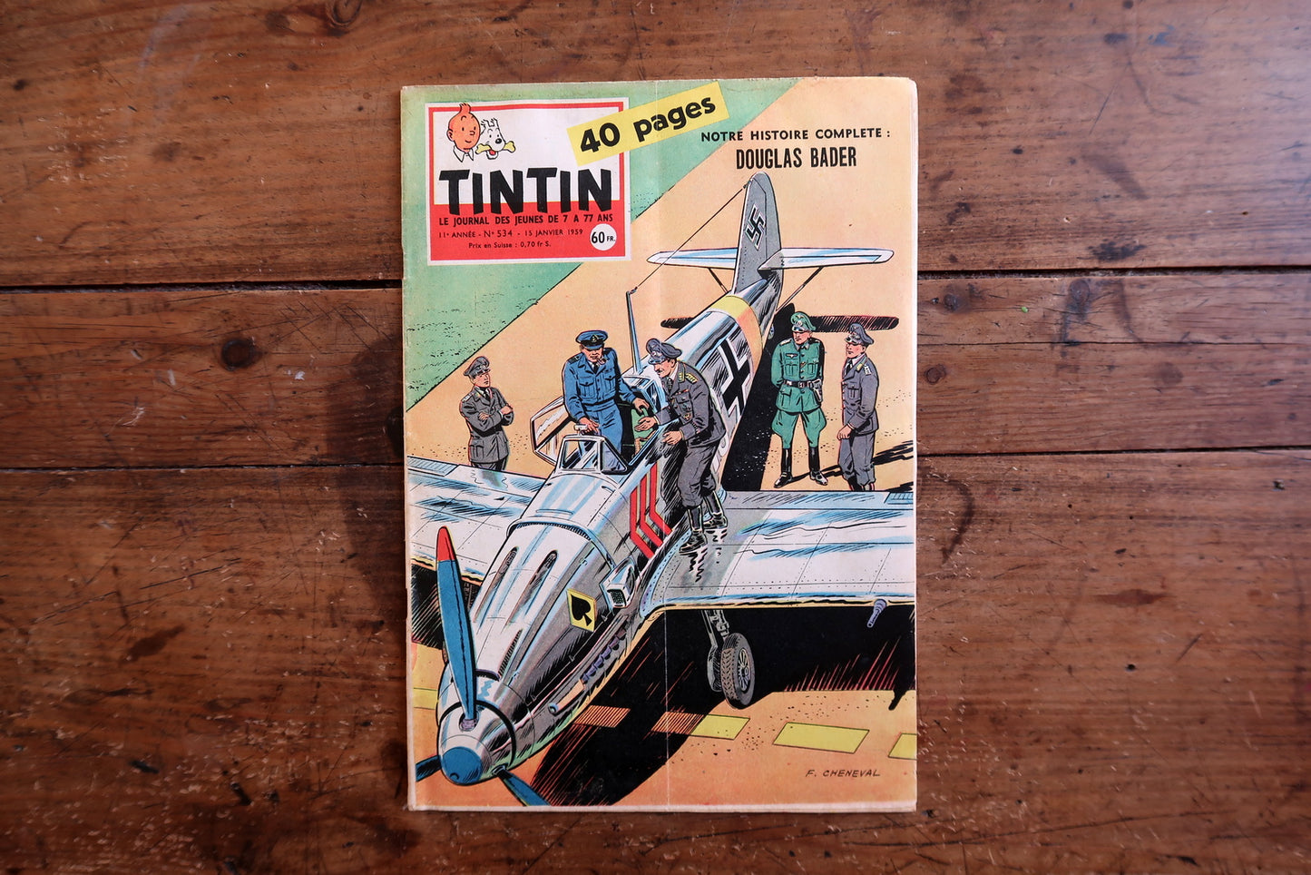 Vintage January 29, 1959 Tintin magazine issue N°534 displayed flat, measuring approximately 8.3 × 11.8 inches, with French language text and bande dessinée artwork, showing significant cover warping and spine splitting with cover partially detached (condition disclosed).

