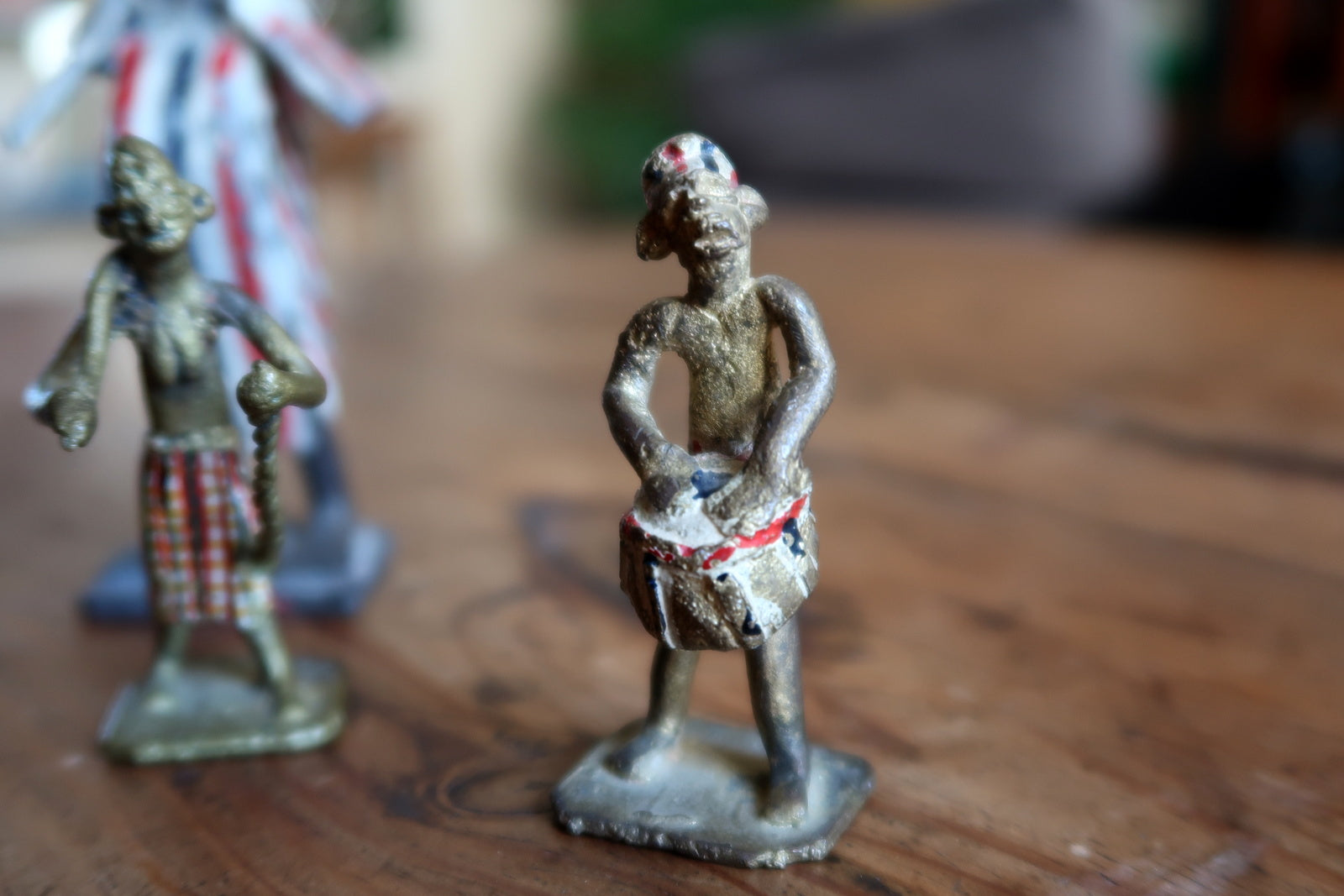 Full group shot of a complete mid-century French colonial-era ceremonial scene figurine set, comprising four objects with original hand-painted surfaces and honest age-related chipping consistent with 65–75 years of age.


