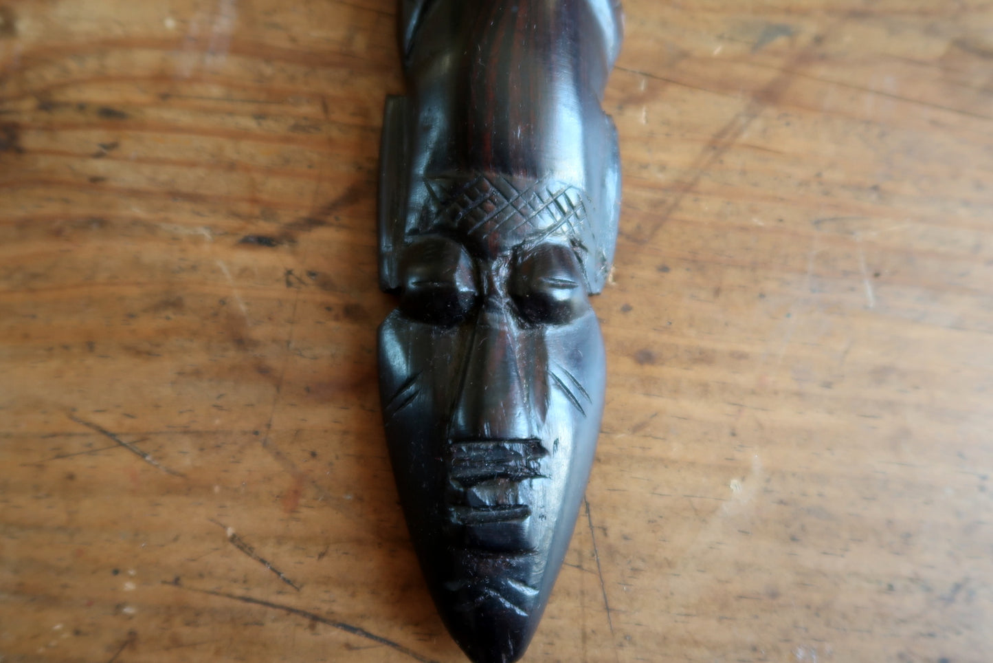 Vintage West African decorative mask from the mid-20th century (circa 1960s–1980s), hand-carved in ebonized hardwood with a tall pointed crest, serene expression, and fine incised scarification patterns on the face.

