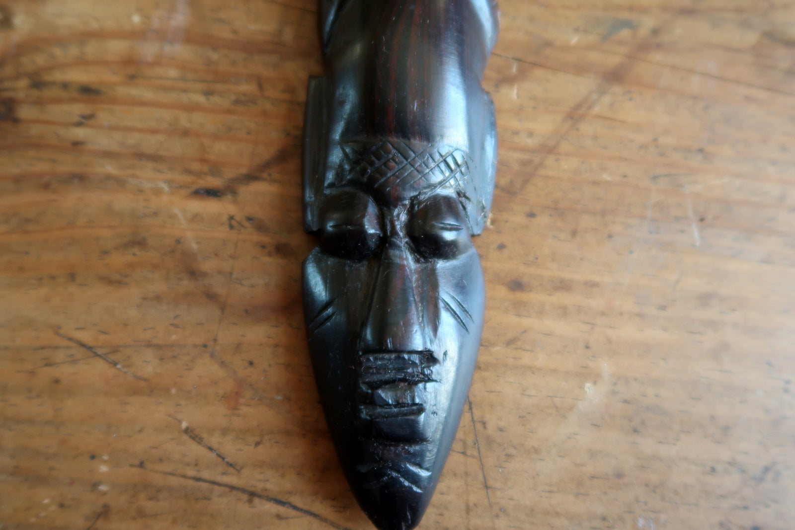 Vintage West African decorative mask from the mid-20th century (circa 1960s–1980s), hand-carved in ebonized hardwood with a tall pointed crest, serene expression, and fine incised scarification patterns on the face.

