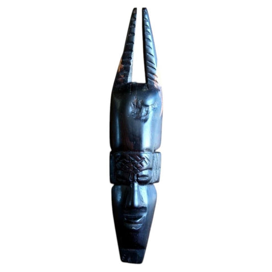 African carved ebonized wood mask with twin‑horn crest from West Africa

