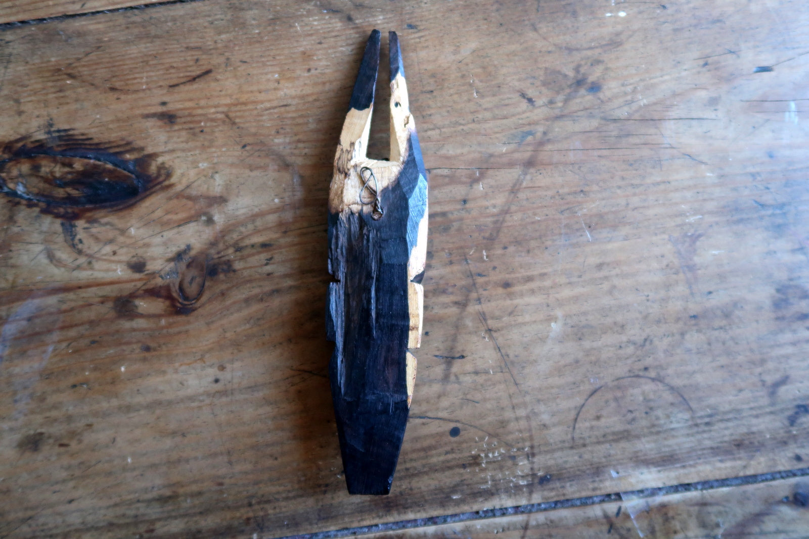 Hand‑carved African mask with elongated face and twin‑horn crest detail

