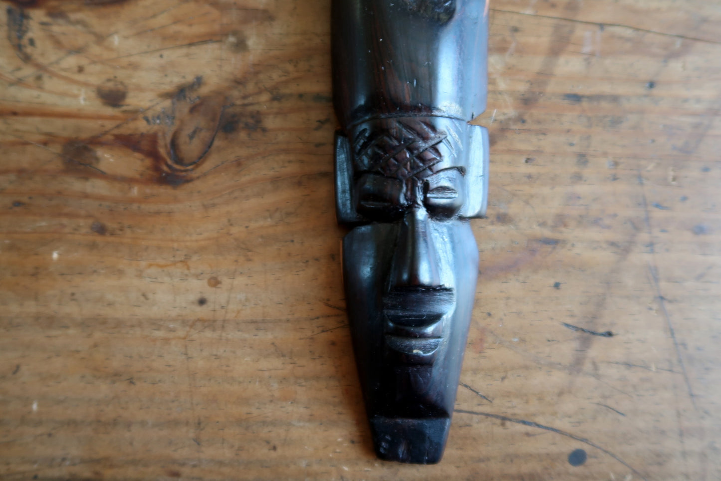 20th‑century West African wooden mask with dark ebonized finish and horn motif


