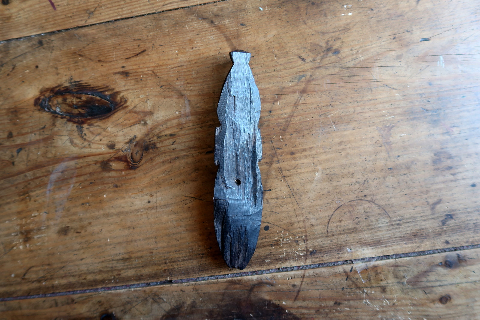 Carved African mask — elongated facial features with leaf‑patterned crest

