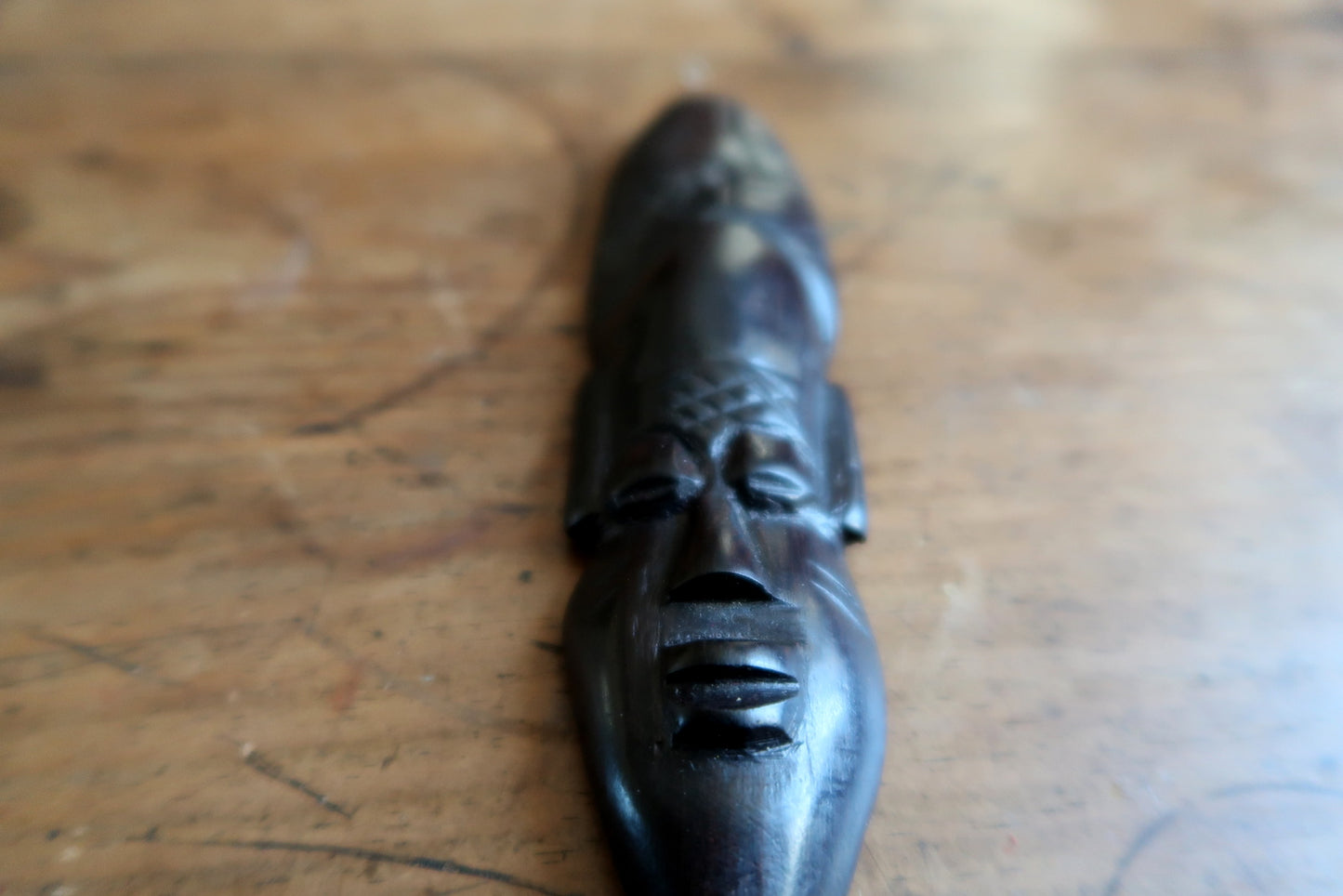 West African wood mask — ebonized finish and decorative herringbone crest

