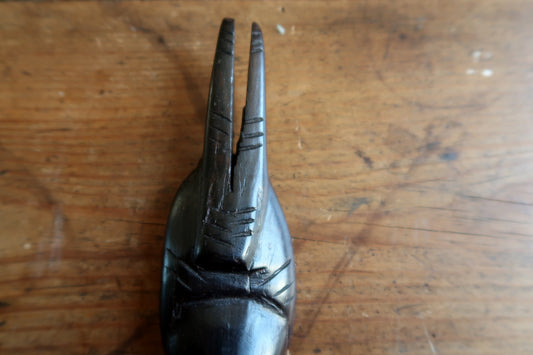 West African tribal mask — powerful facial carving and vertical double‑prong headdress

