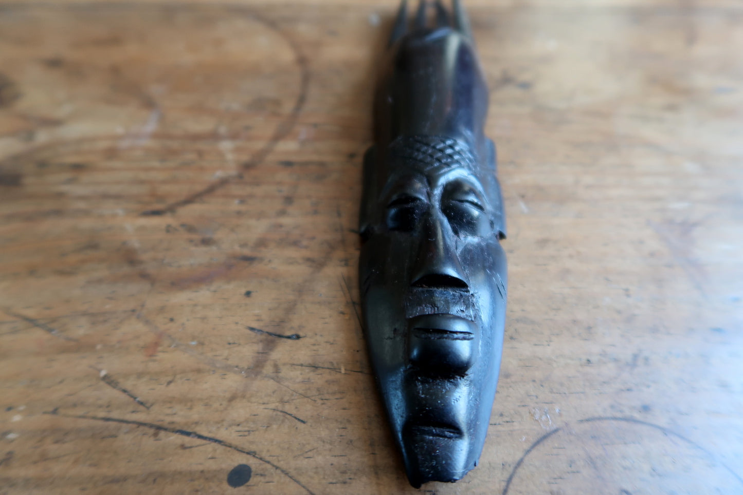 African ceremonial mask — expressive carved face and vertical crest design

