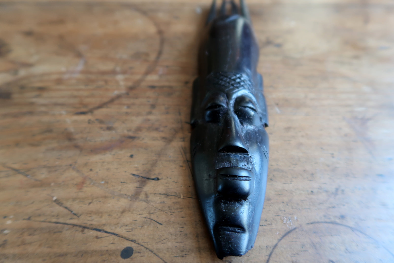 African ceremonial mask — expressive carved face and vertical crest design


