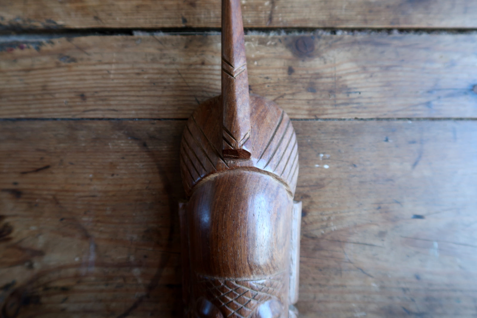 West African tribal mask — carved features and single‑prong crest

