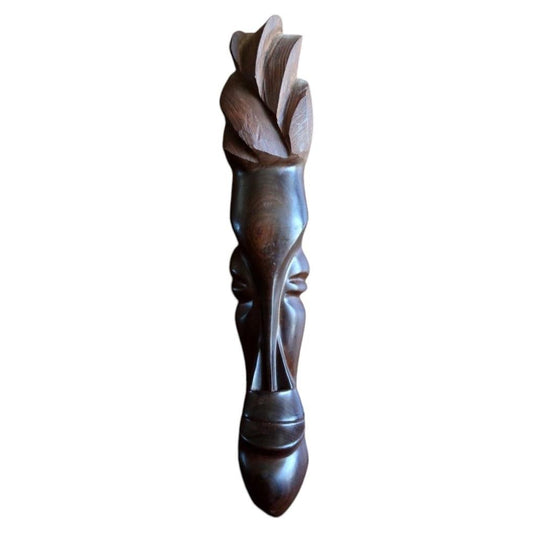 Front view of a mid-20th century West African carved dark hardwood mask featuring an elongated abstract face, petal crest, and rounded spatula base.