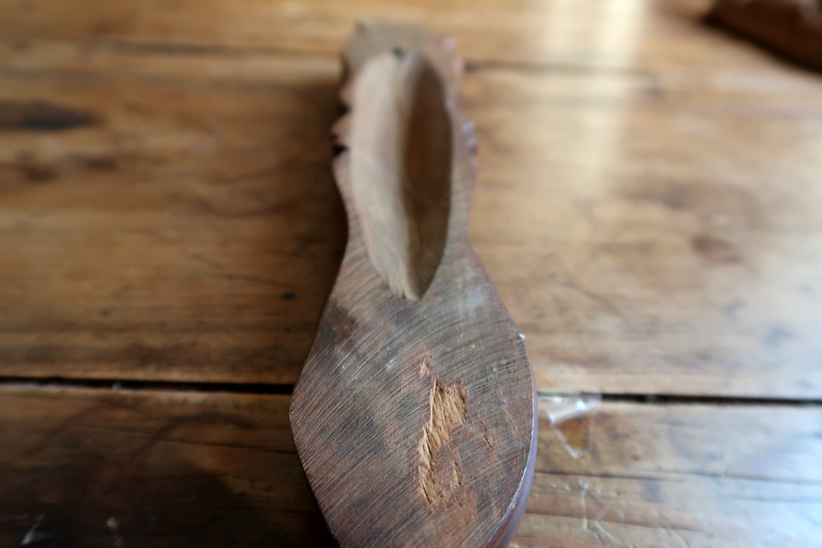Bottom-up perspective showing the tapered spatulate base and slender 5 cm width of the mid-century hand-carved mask.