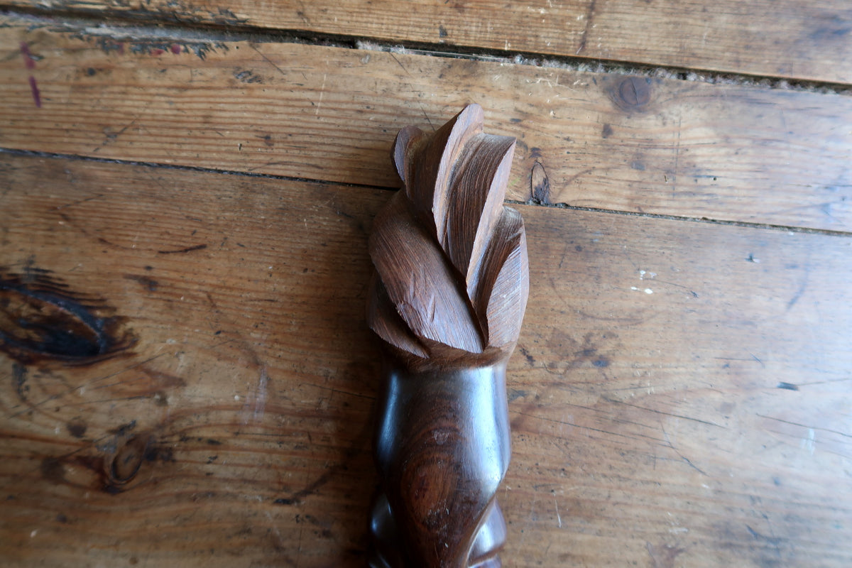 Reverse side of the African hardwood mask showing the raw, unfinished pale wood interior and single drilled hanging hole near the top.