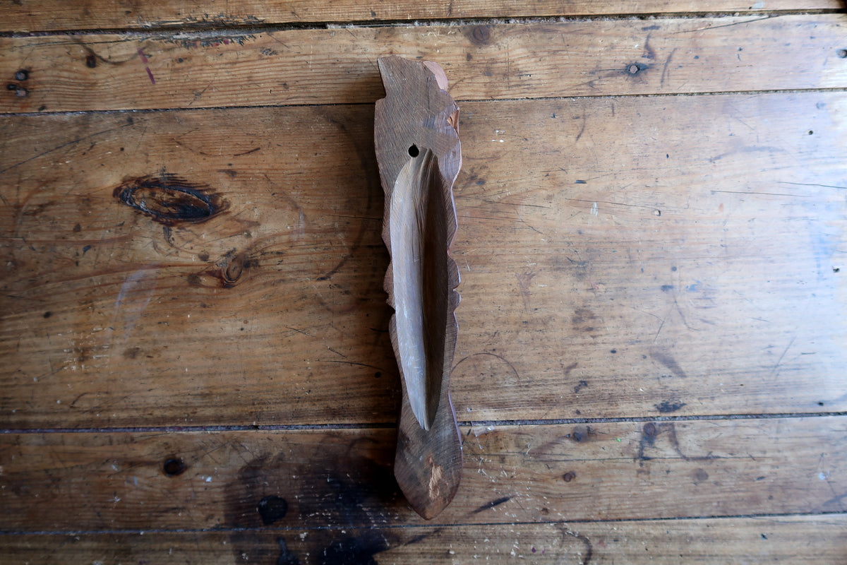 Detailed view of the raw wood back edge showing the authentic hand-carved texture and minor hairline split disclosed on the reverse.