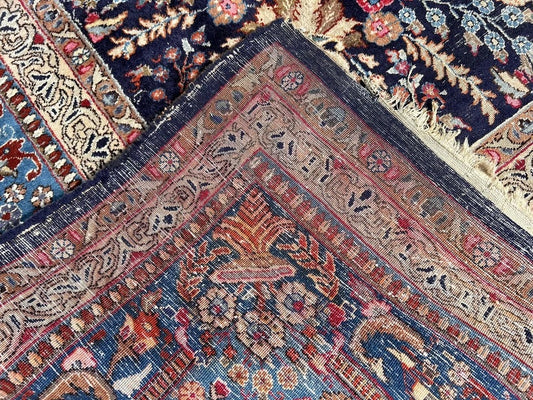 Close-up of floral vines on 1920s Kashan rug

