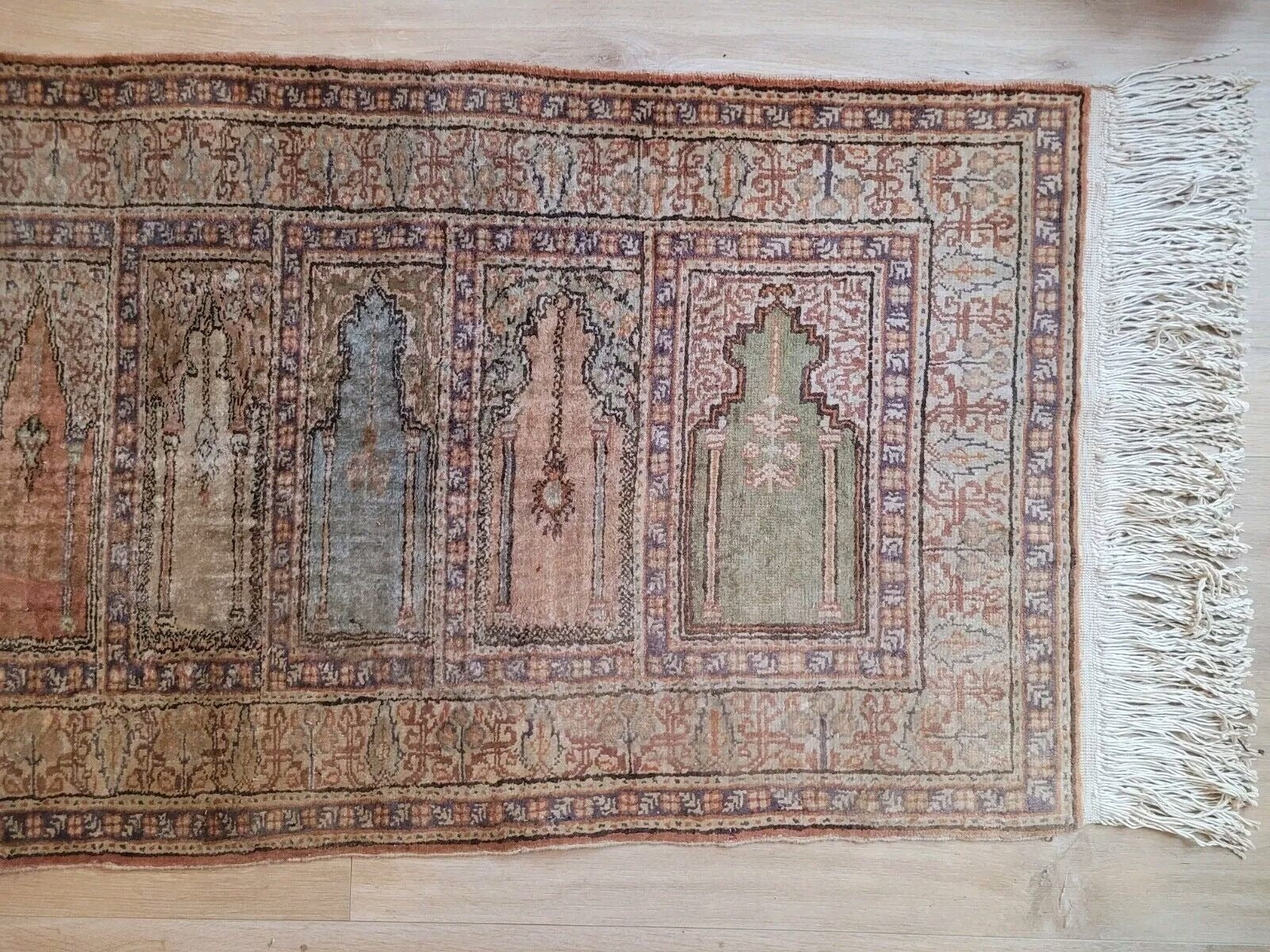 View of symmetrical mihrab motifs on antique runner


