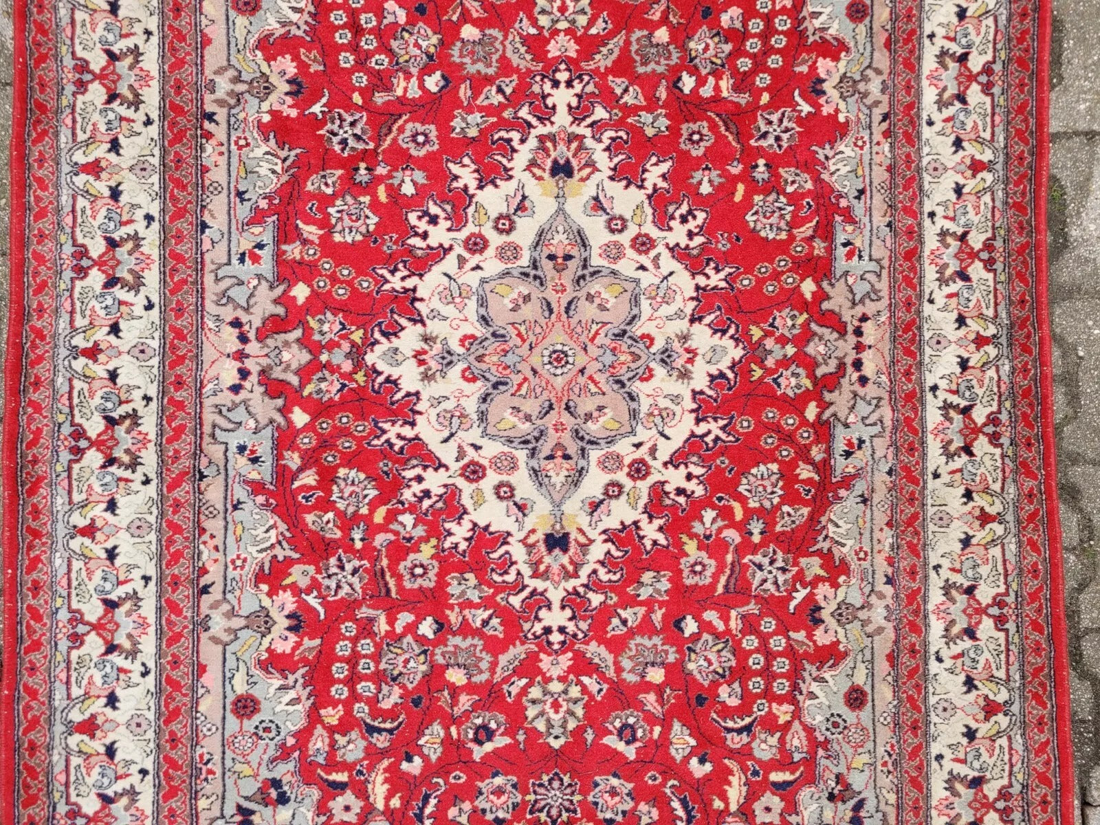 Vintage wool rug in crimson red with ivory and navy blue patterns.
