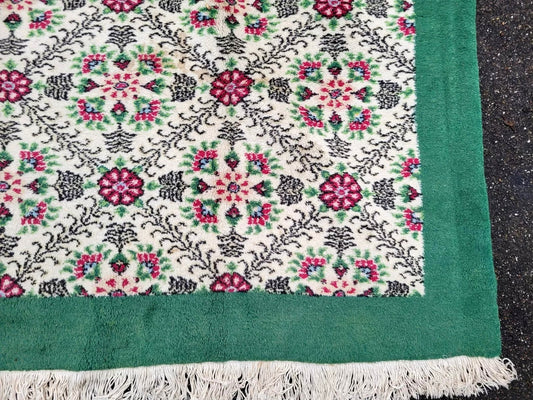 Wool rug featuring a creamy ivory background with stylized rose bouquets.
