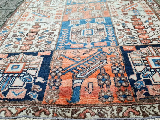 Wool rug featuring a grid of varied floral and geometric motifs.
