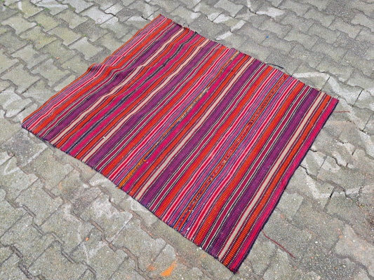 Wool flat-weave rug featuring a kaleidoscope of colors.
