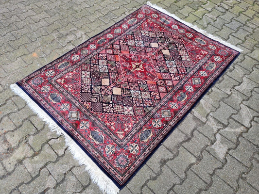 Wool rug featuring a deep navy blue field and intricate florals.
