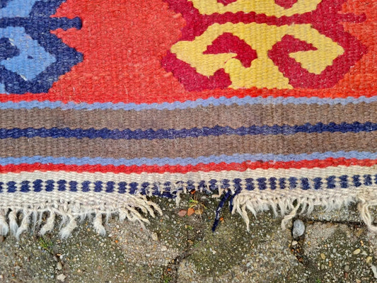 Bright red and navy tribal motifs on vintage kilim

