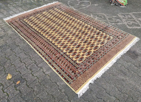 Full view of vintage Bukhara rug in cream and red

