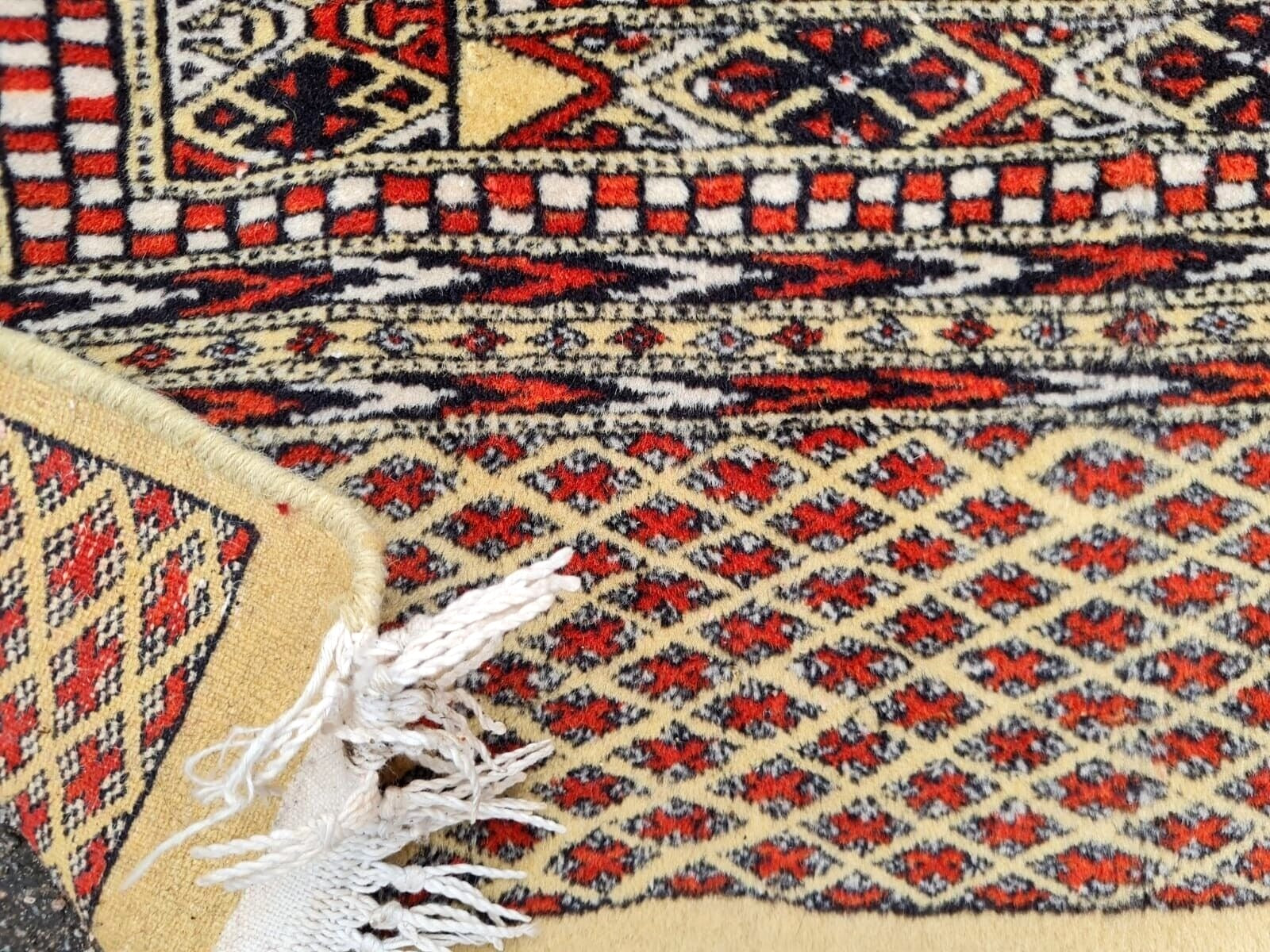 Cream field Bukhara rug with tribal borders

