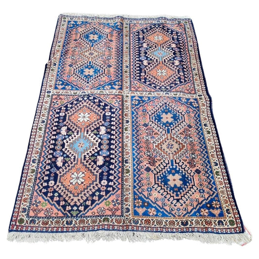 Vintage Persian Luri rug with deep red field and geometric patterns

