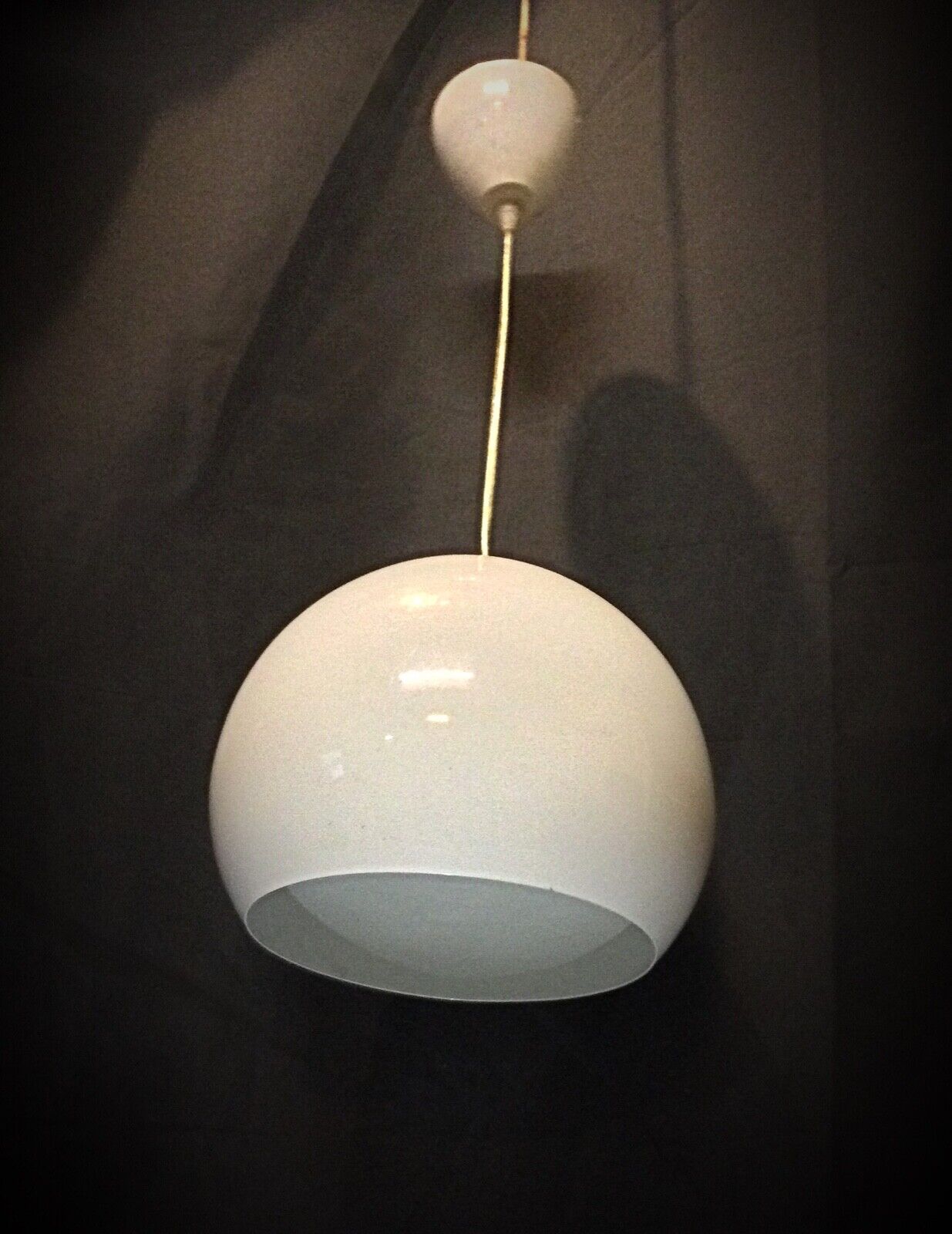 The vintage lamp suspended from a ceiling, showcasing its retro charm
