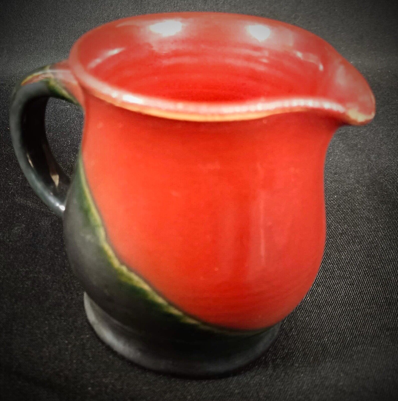 Close-up of Michel Poully's signature on a ceramic pitcher
