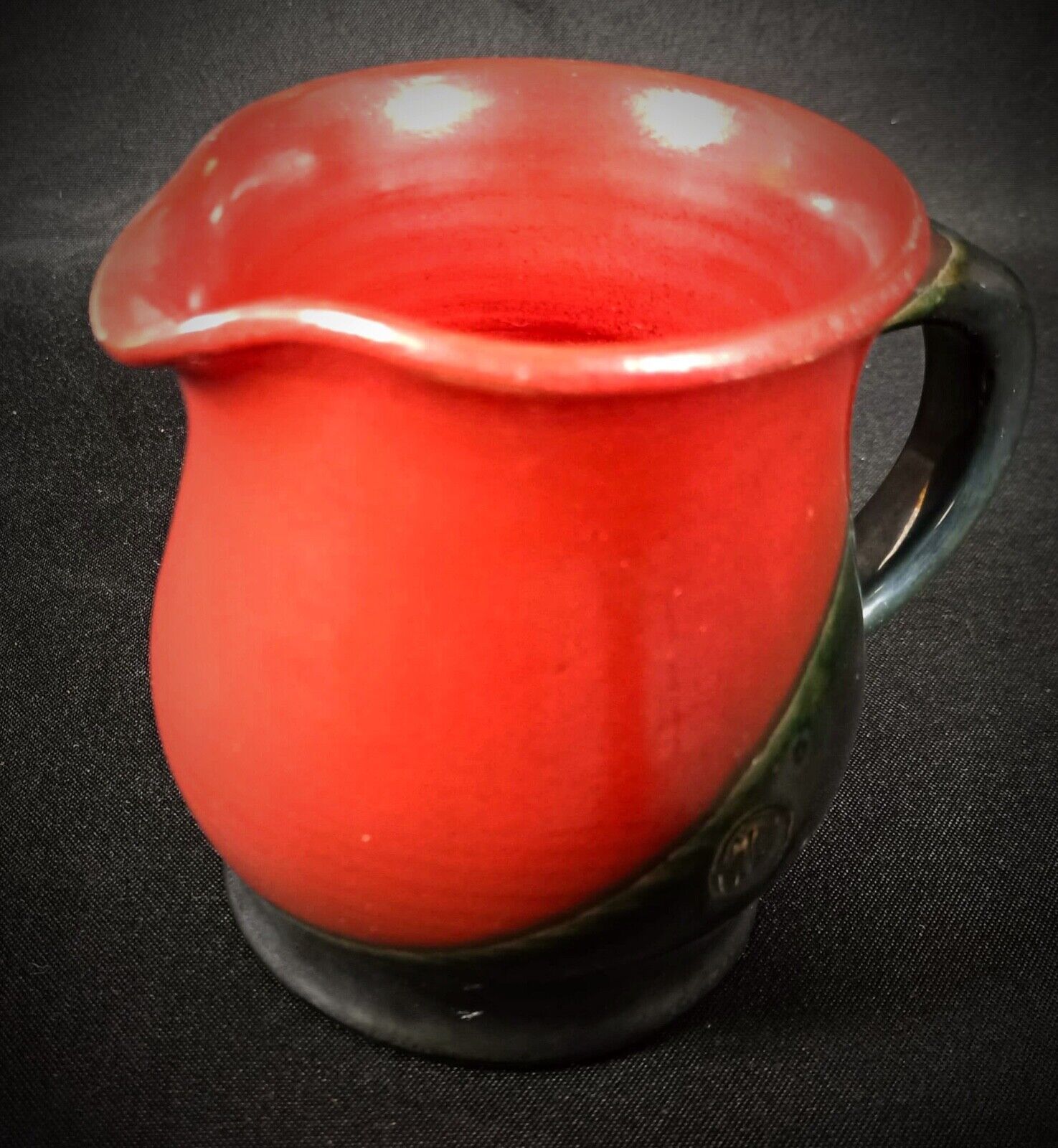 Signed ceramic pitcher with a modern, elegant form

