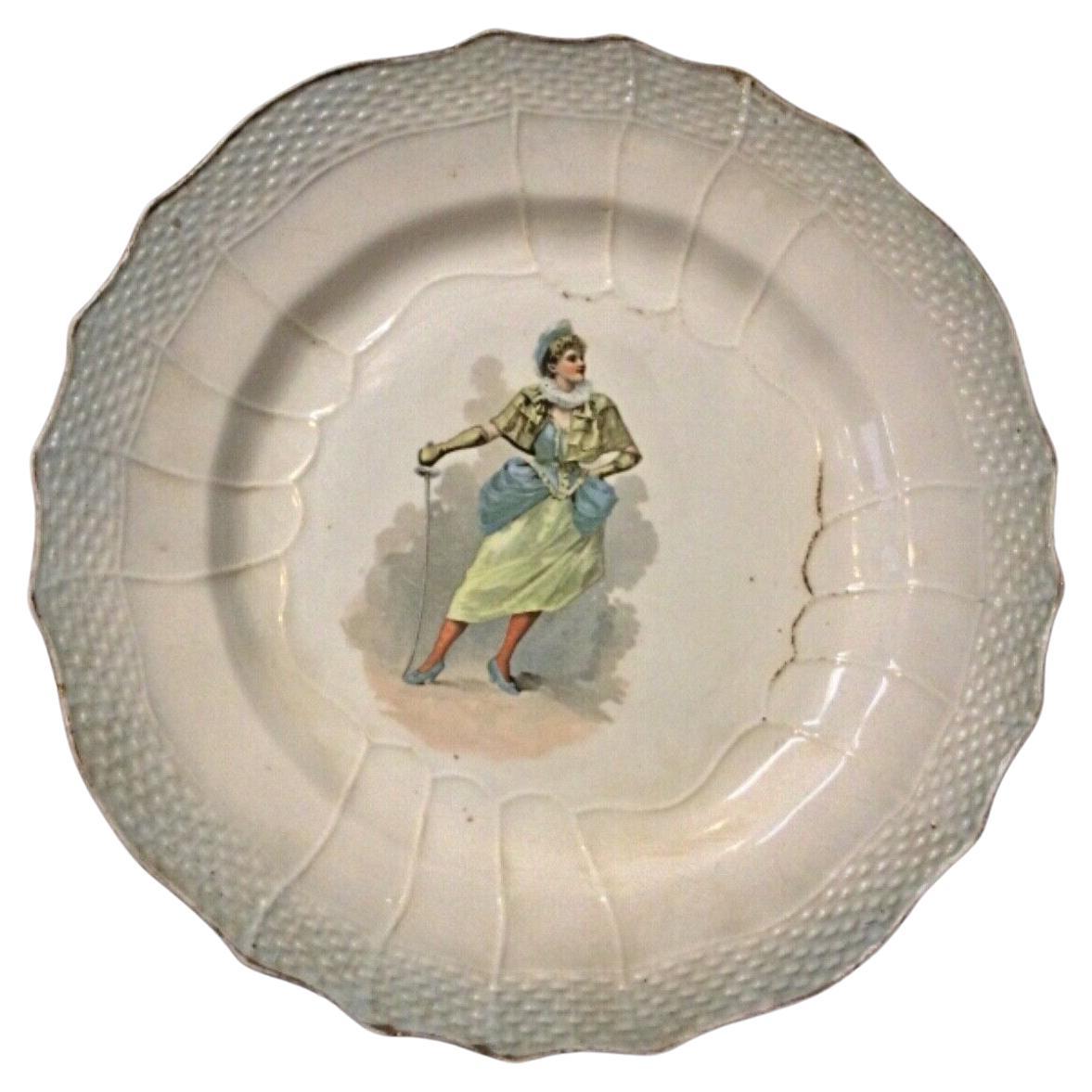 Antique faience plate with the "Hamage Nord" design, featuring a woman with a sword.
