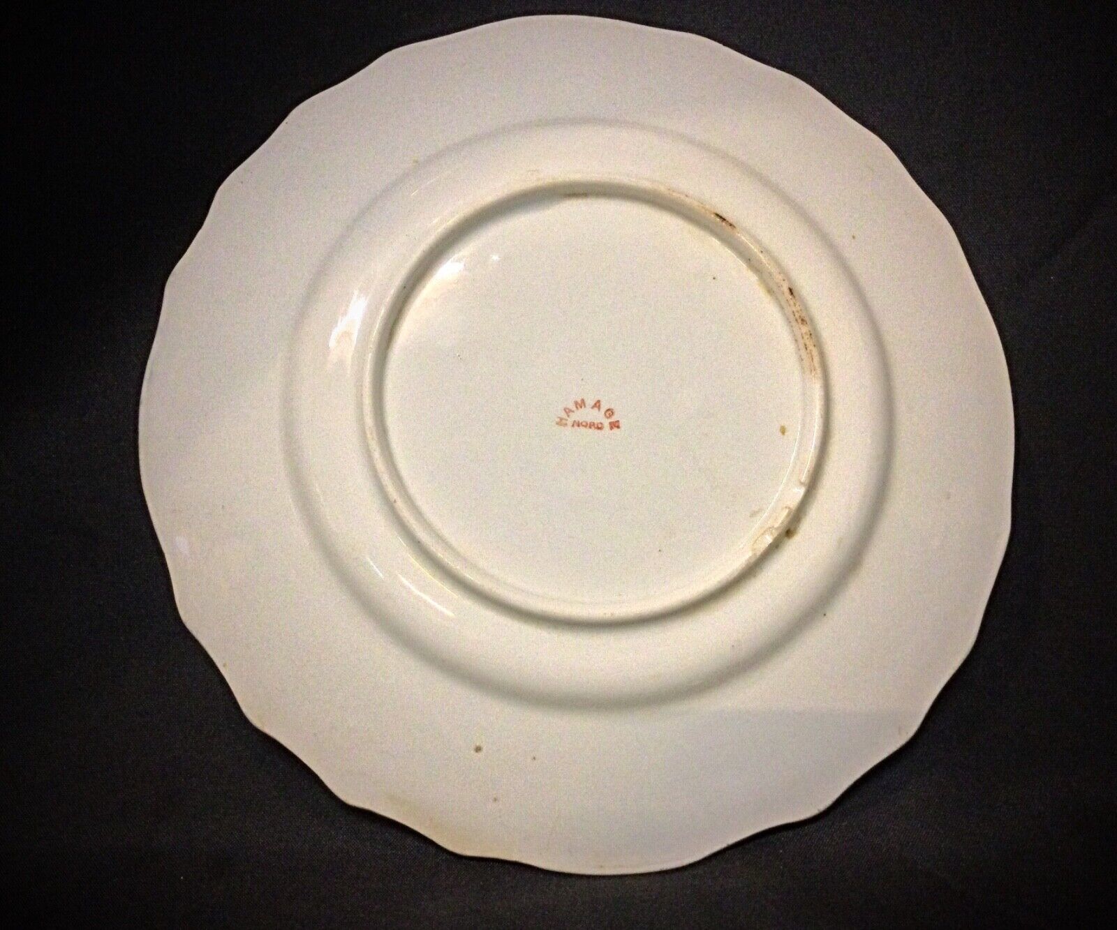 Back view of the antique faience plate showing signs of age-related wear.

