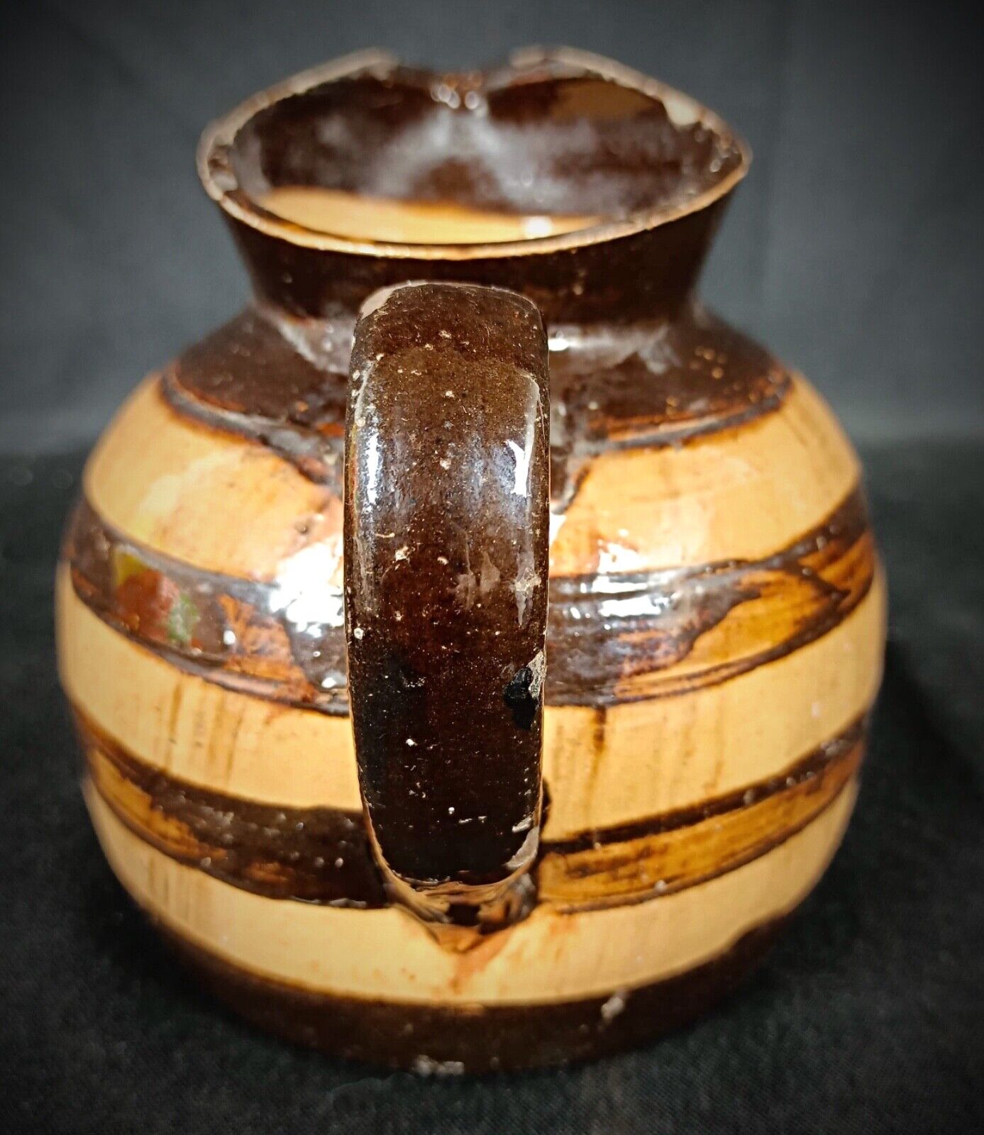 Barrel-shaped clay pitcher with earthy tones and vintage finish
