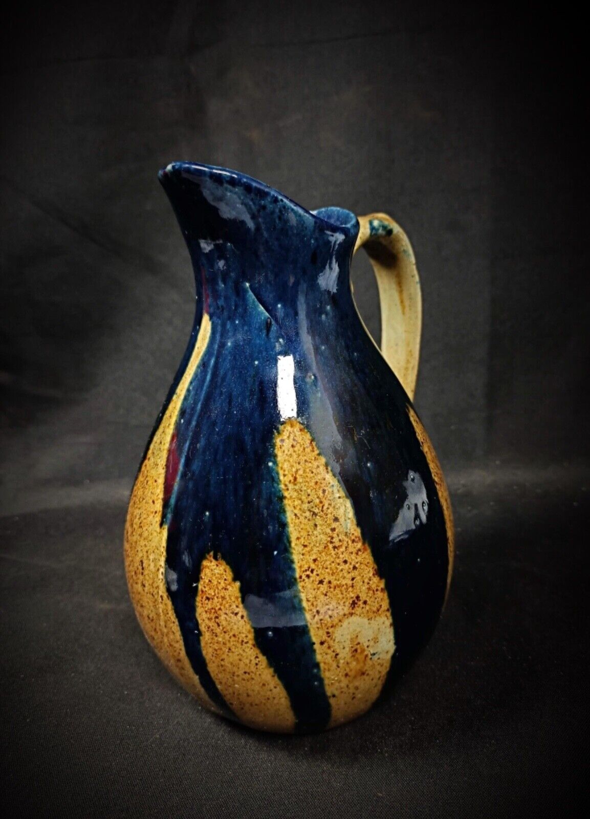 Side view of blue and brown enamel pitcher with handle

