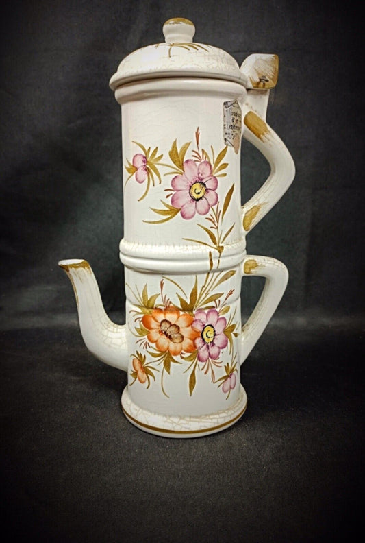 Decorative ceramic teapot with floral patterns on a dark background