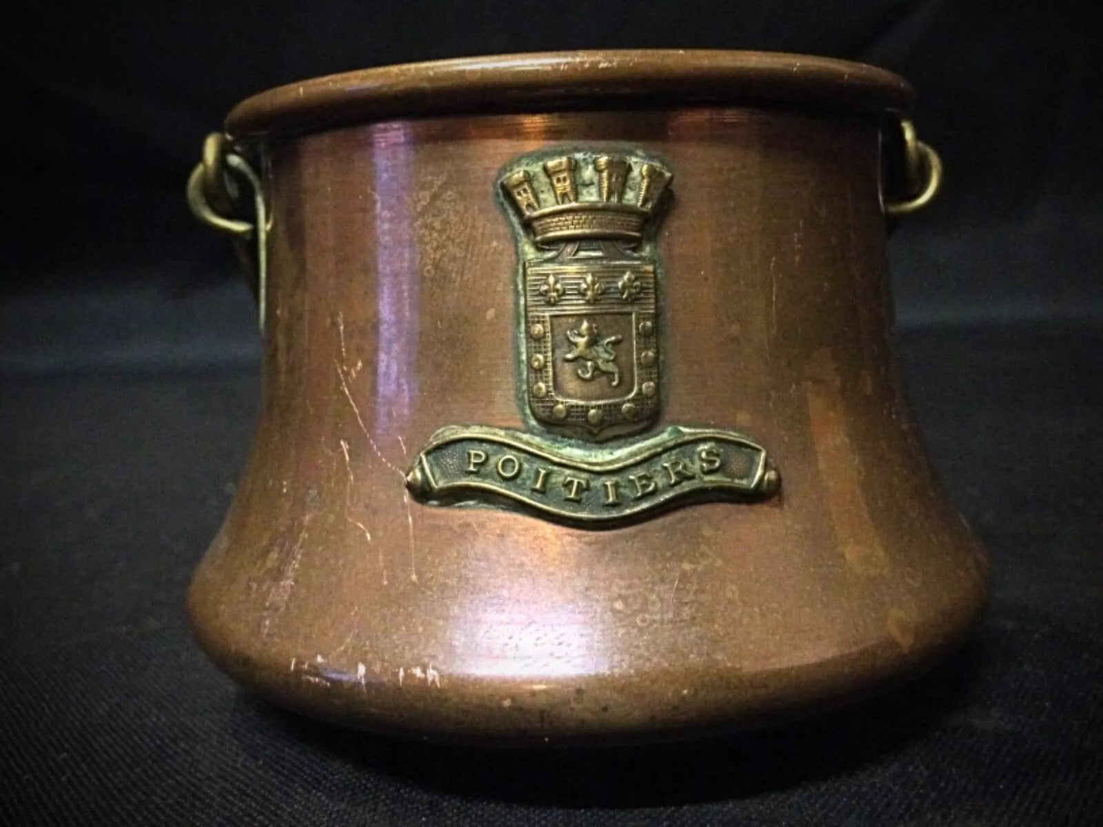 Antique copper cauldron displayed on a table, highlighting its vintage charm and design.