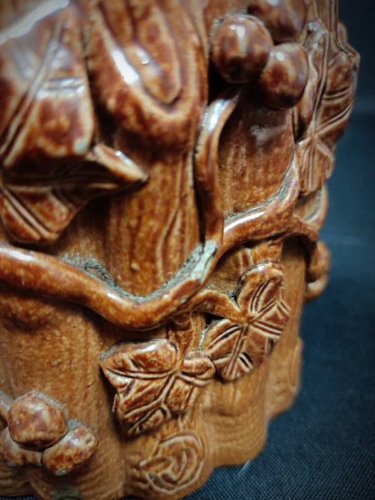 Rustic clay pot featuring vineyard carving

