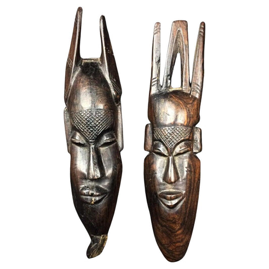 Front view of both African wood masks displayed together

