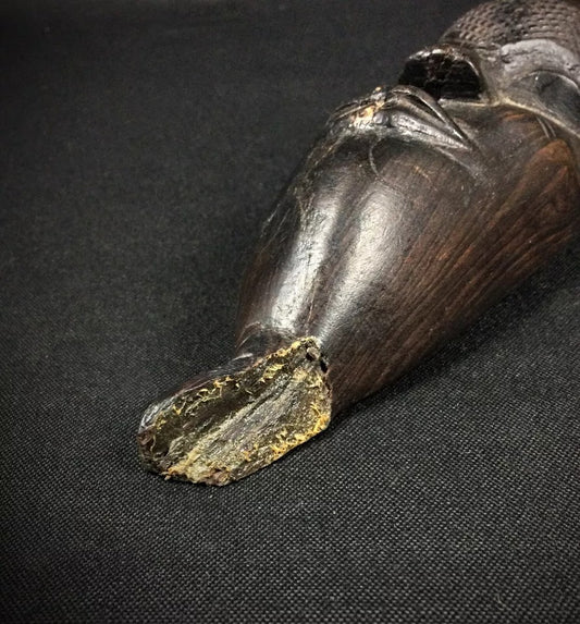 Close-up detail of the first mask's carved facial features

