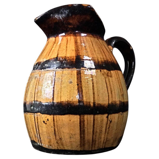 Front view of antique barrel-shaped ceramic pitcher showing full form

