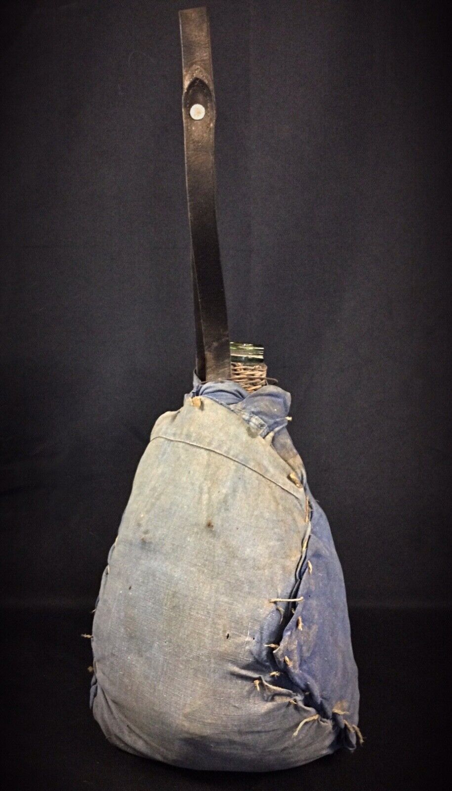 Side profile showing the classic bulbous shape of the clear glass bottle inside the case.

