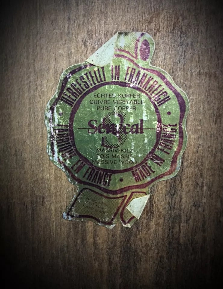 Close-up of detailed copper reliefs and craftsmanship on a signed Sénécal decorative wall plate from the XXth century