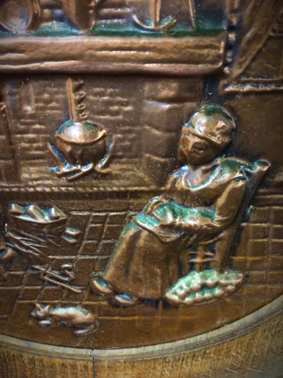 Detail of artist signature by Sénécal on the wood background of a vintage French copper relief wall plate