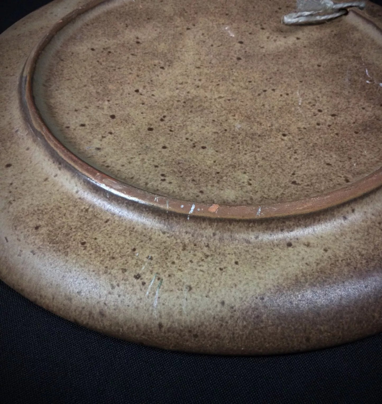 Textured ceramic surface with weaver bas-relief artwork

