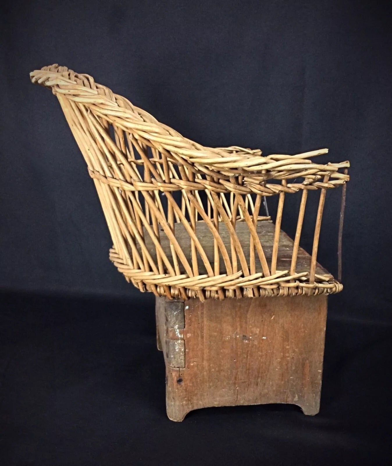 Handcrafted wooden children's chair circa early 20th century with natural wicker details

